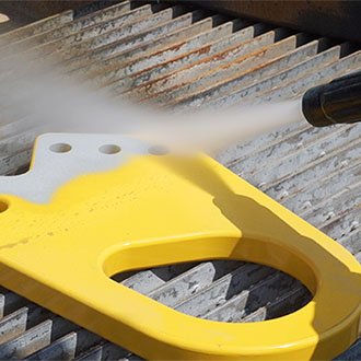 Vapor Blasting Thick Yellow Powder Coating off an industrial metal part