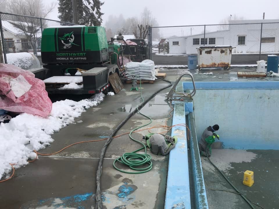 blasting blue paint off of a concrete pool
