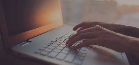 Woman typing on laptop at workplace working in home office hand keyboard