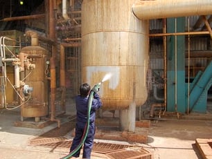 rust being removed from storage tank with abrasive blasting