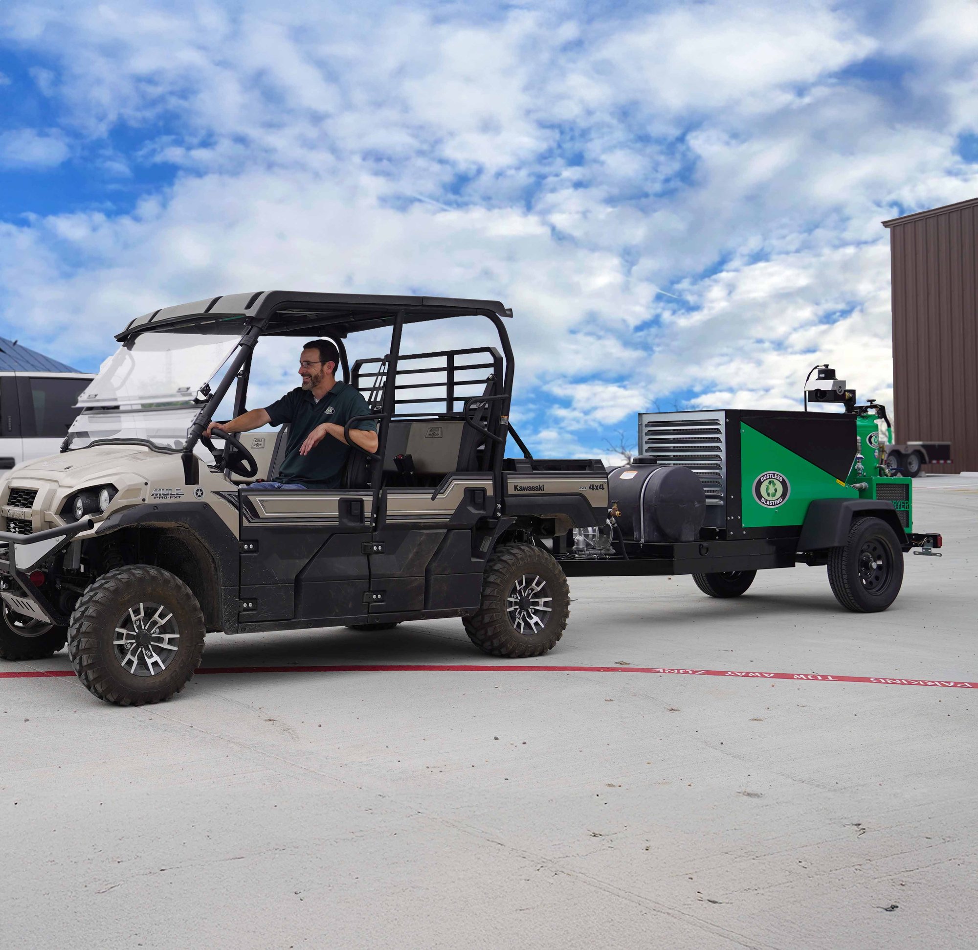 Dustless Blasting's DB350 Mobile XS sandblasting trailer being towed behind a small vehicle