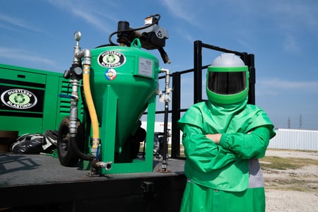 Man in Nova PPE with Dustless Blasting blast pot