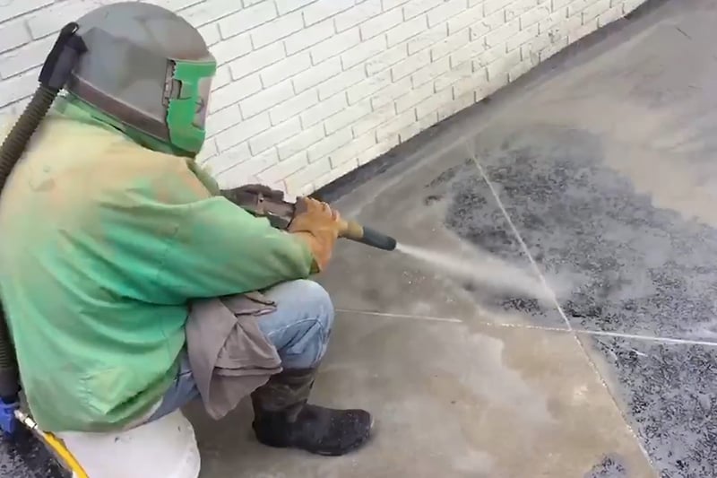 sandblasting removing grime from stamped concrete