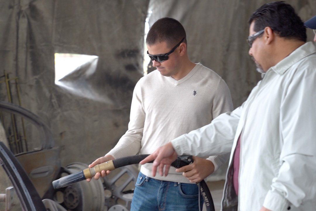 two men in white shirts holding hose